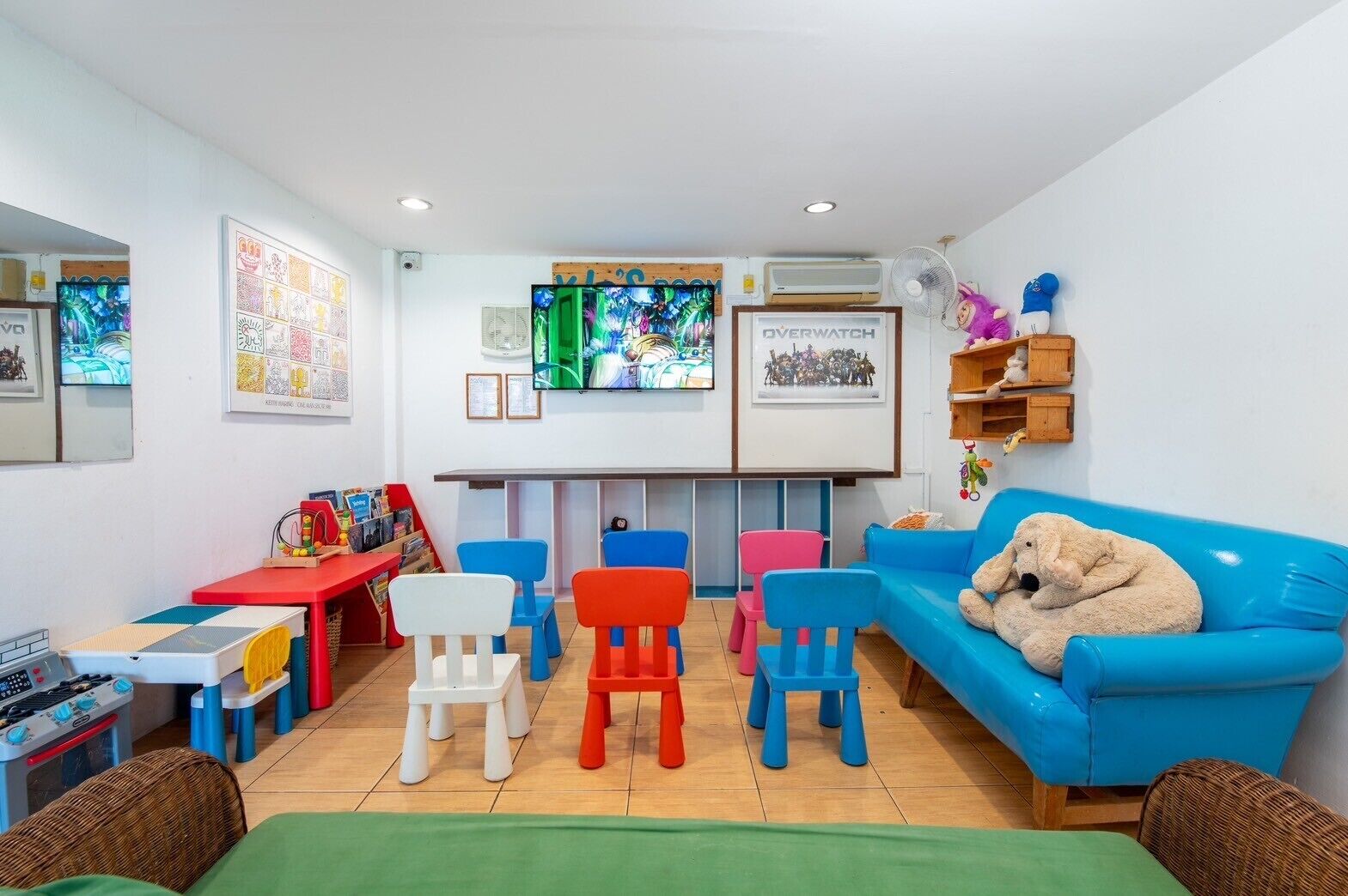 A children's playroom with colorful furniture, a television, and various toys.