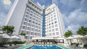 Ein Hotel mit großem Pool, mehreren Etagen und einer Bar.