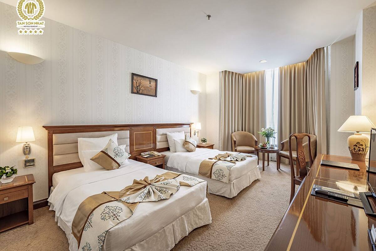 Een hotelkamer met twee bedden, een bureau, een stoel en een televisie.