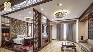 Ein Hotelzimmer im traditionellen Stil mit einem großen Bett, einem Sofa, einem Couchtisch und einem Fernseher.