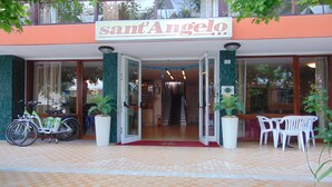 The entrance to Sant'Angelo hotel with a tiled pavement, a bicycle parked outside, and a sign above the entrance. - Hotel Sant'Angelo (Riccione)
