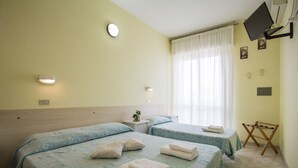 A hotel room with two beds, a TV mounted on the wall, and a window with curtains. - Hotel Sant'Angelo (Riccione)