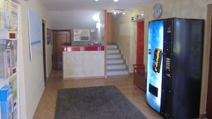A kitchen with a refrigerator, a microwave, and a clock on the wall. There is a staircase leading to another level. - Hotel Azcona (Noja)
