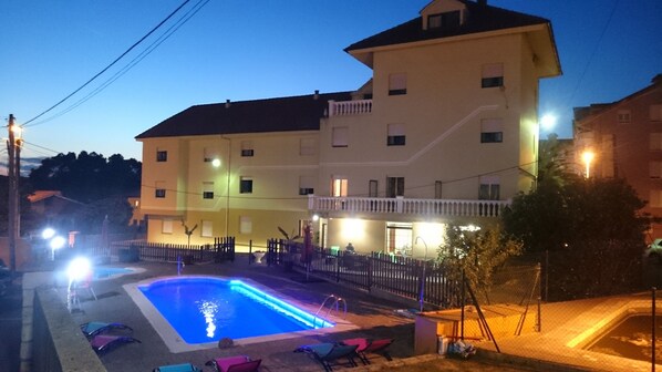 Una piscina al aire libre, sombrillas, tumbonas