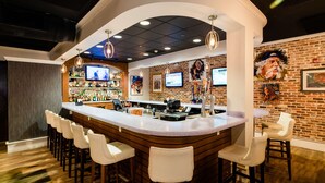 A bar area with a curved counter, multiple stools, and a brick wall backdrop. - Hotel Florence, Tapestry Collection by Hilton (Florence)