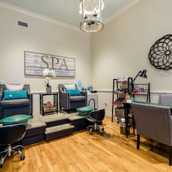 Relax in this serene spa room with a comfortable seating area, armchairs, sofa, and a small table with a lamp.