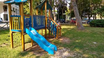 Children can play on the playground's slide, climbing area, and shelter.