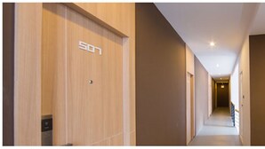 Un couloir avec une pancarte indiquant le numéro « 507 » et une autre pancarte indiquant « MY hotel ».
