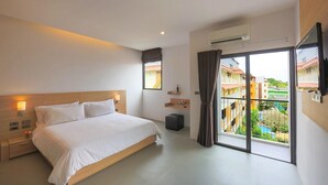 Une chambre d’hôtel moderne avec un grand lit, des lampes de chevet, une petite table avec un vase, un balcon donnant sur les bâtiments et un appareil de climatisation.