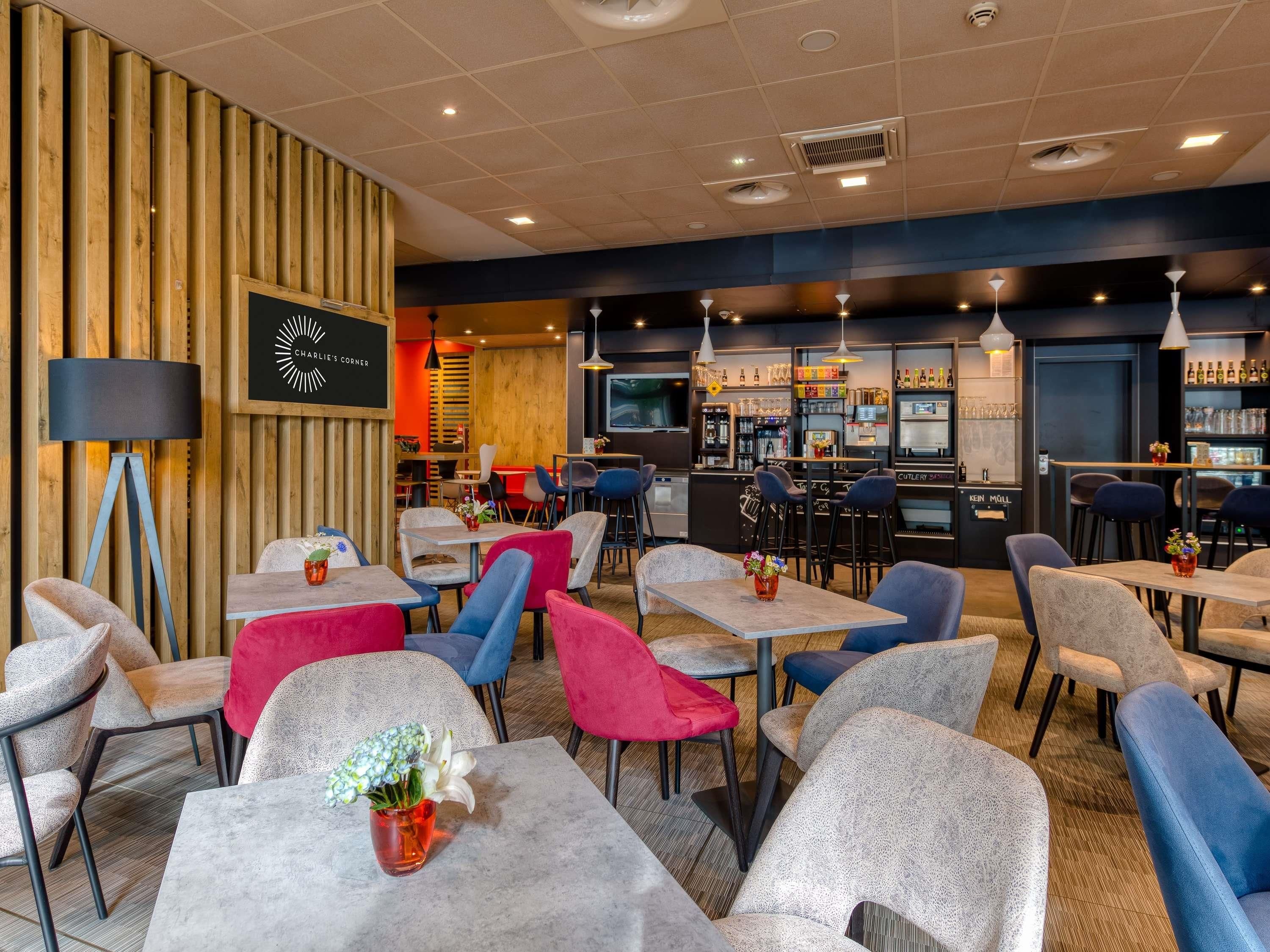 Un restaurant doté d’un bar, de plusieurs espaces pour s’asseoir et d’un menu affiché en évidence.