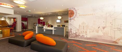 A reception area with a desk, chairs, and a wall with a map and text.