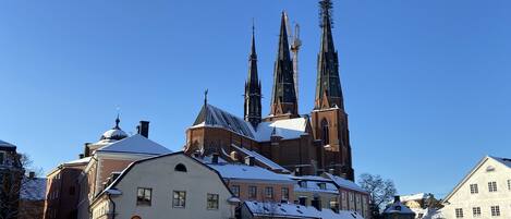 A historic church with two tall spires, surrounded by snow-covered buildings.