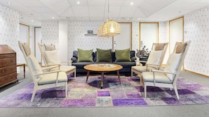 A modern room with a sofa, two armchairs, a coffee table, and a patterned rug. - Best Western Uppsala (Uppsala)
