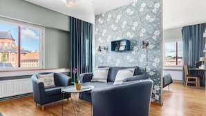A modern living room with a sofa, two armchairs, a small round table, and a potted plant. - Best Western Uppsala (Uppsala)