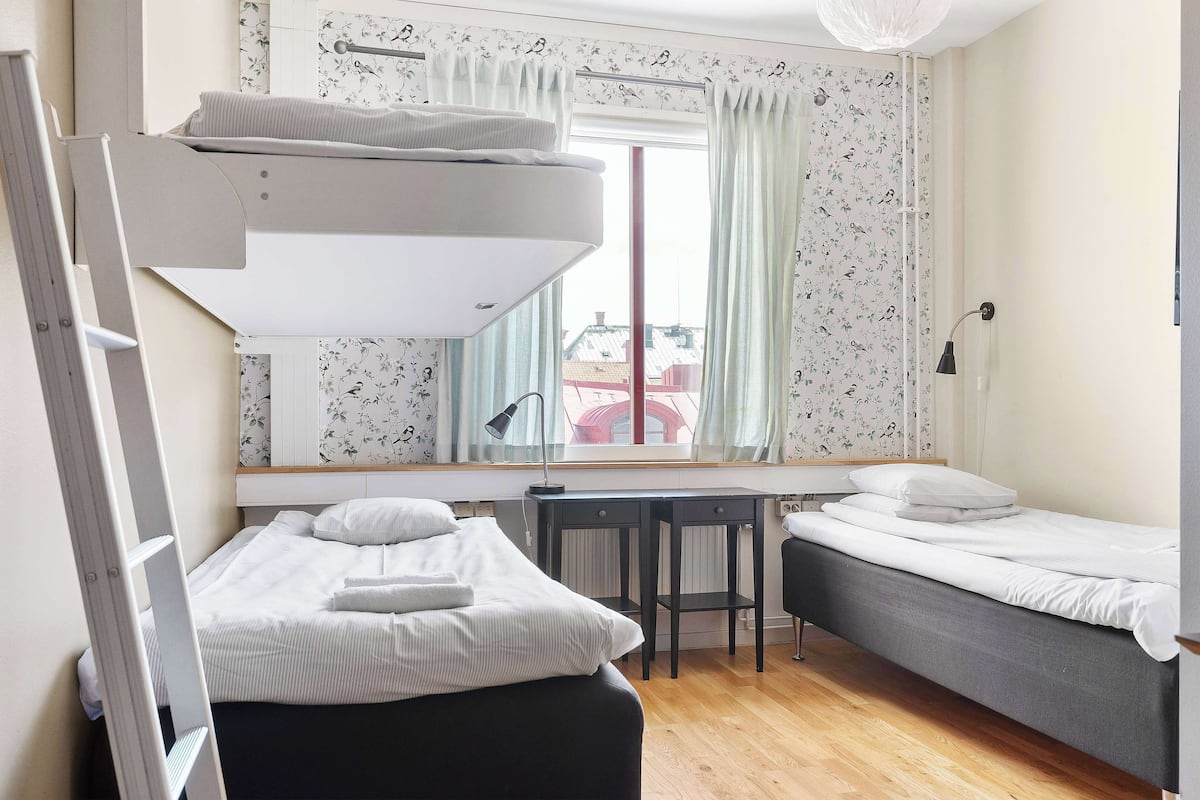 A bedroom with a bunk bed, a desk, and a chair.
