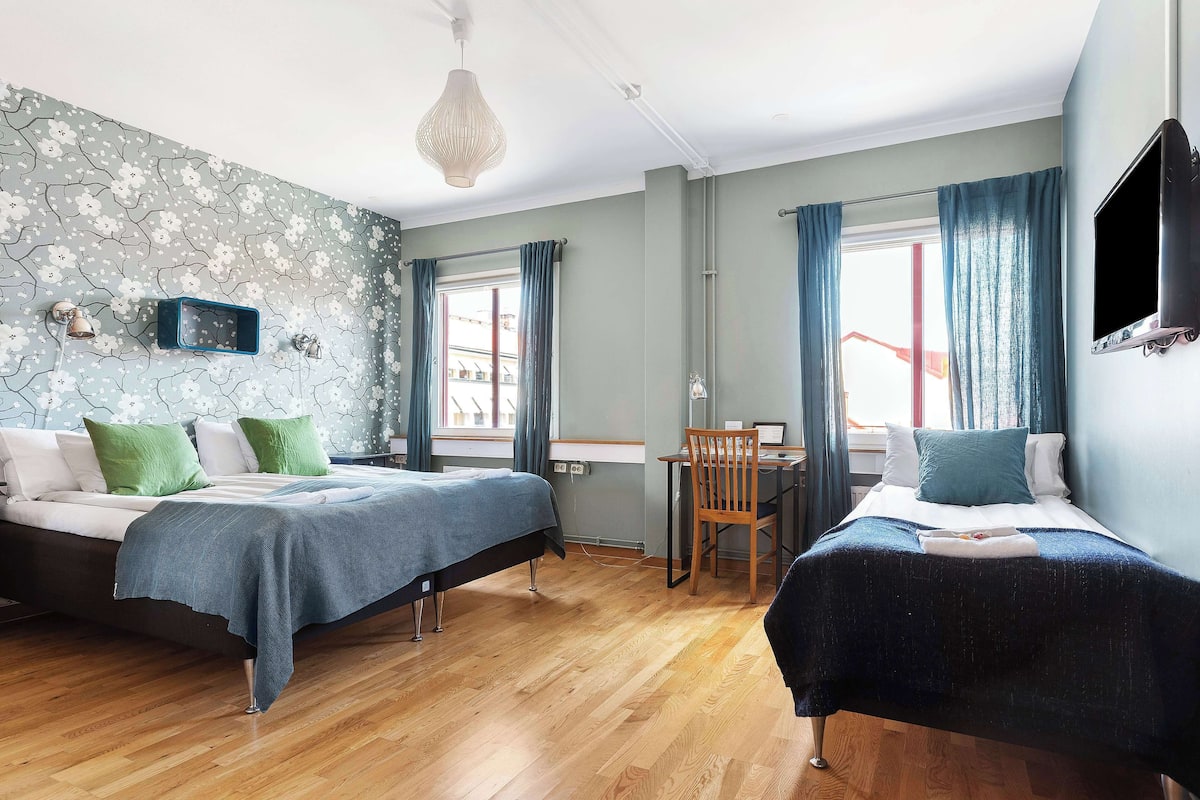 A room with two beds, a desk, and a chair.