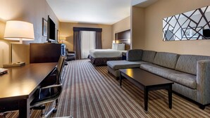 A hotel room with a bed, a sofa, a desk with a chair, a TV, and a lamp. - Best Western Plus North Odessa Inn & Suites (Odessa)