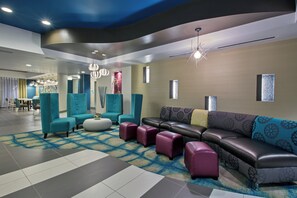A modern lobby with seating areas, a patterned carpet, and contemporary lighting fixtures. - Holiday Inn Express Hotel & Suites, Carlisle-Harrisburg Area by IHG (Carlisle)