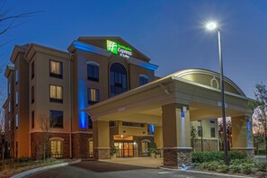 A Holiday Inn Express building with a clear entrance, a covered parking area, and a well-lit facade. - Holiday Inn Express & Suites Orlando East - UCF Area by IHG (Orlando)