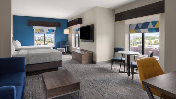A hotel room with a bed, a TV, a desk, and a chair. - Holiday Inn Express & Suites Orlando East - UCF Area by IHG (Orlando)