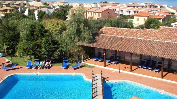 Una piscina al aire libre, sombrillas, tumbonas