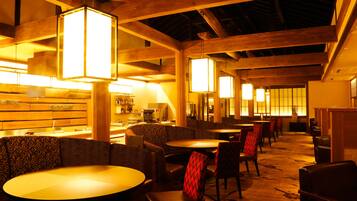 A restaurant with wooden beams, tables, and chairs.