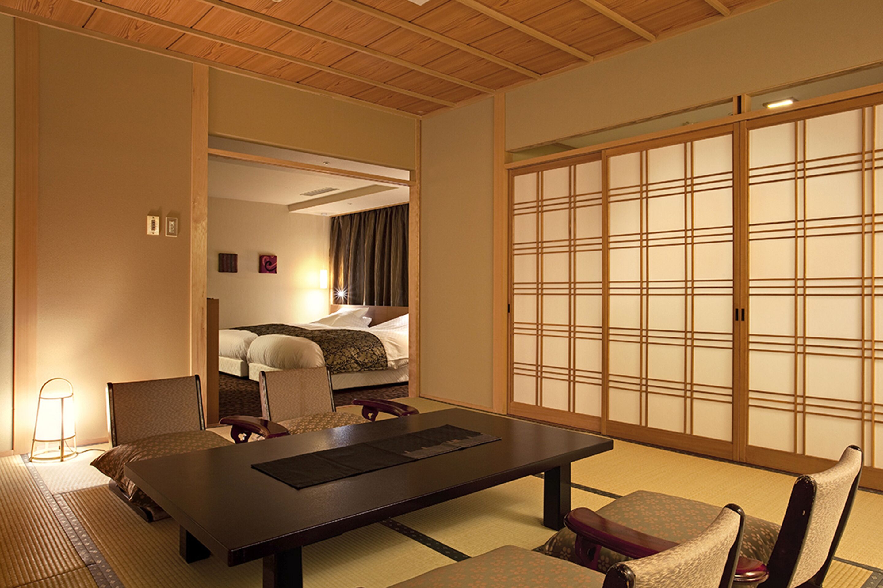 A traditional Japanese-style room with tatami flooring, a low table, and shoji screens.