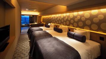 A hotel room with a large bed, a TV, and a balcony with a city view.