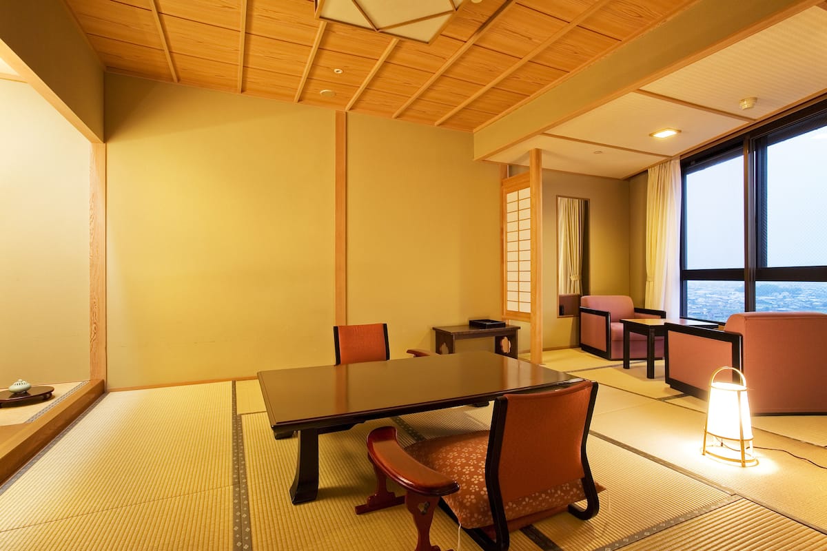Une pièce de style japonais traditionnel, avec un sol recouvert de tatamis, une table basse et des assises confortables.