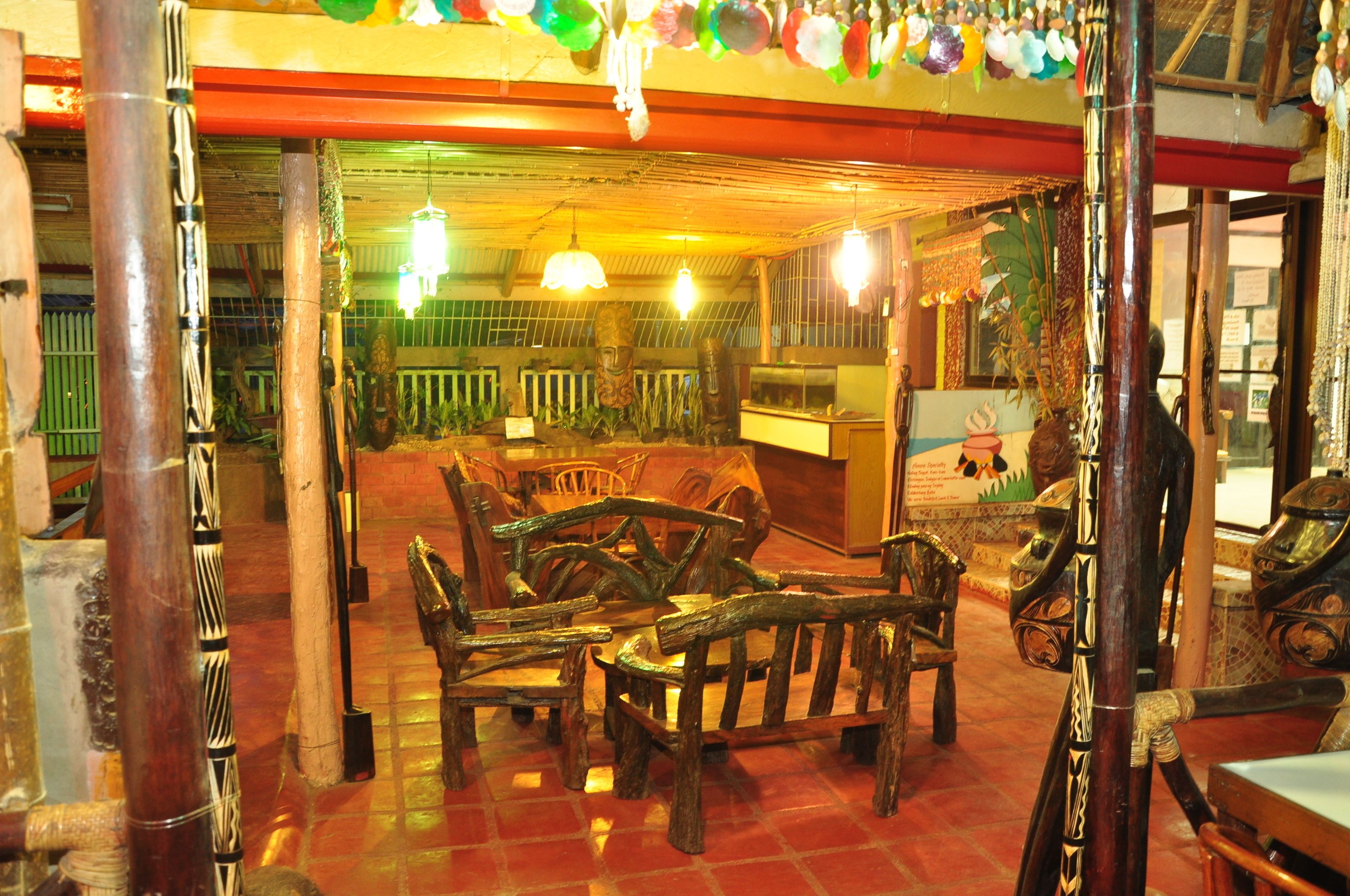 Un interior de madera tradicional con una zona de estar central y un techo decorativo.