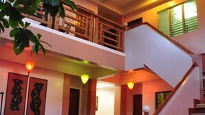 A spacious interior with a staircase, a dining area, and a balcony. - Lola Itang Pension (Puerto Princesa)