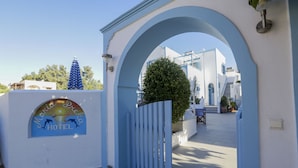 A hotel entrance with a blue archway, a sign reading "Maria & Drako HOTEL," and a view of the hotel buildings in the background. - Preka Maria Hotel (Santorini)