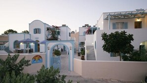 A hotel with a white facade, blue accents, and a central archway. - Preka Maria Hotel (Santorini)