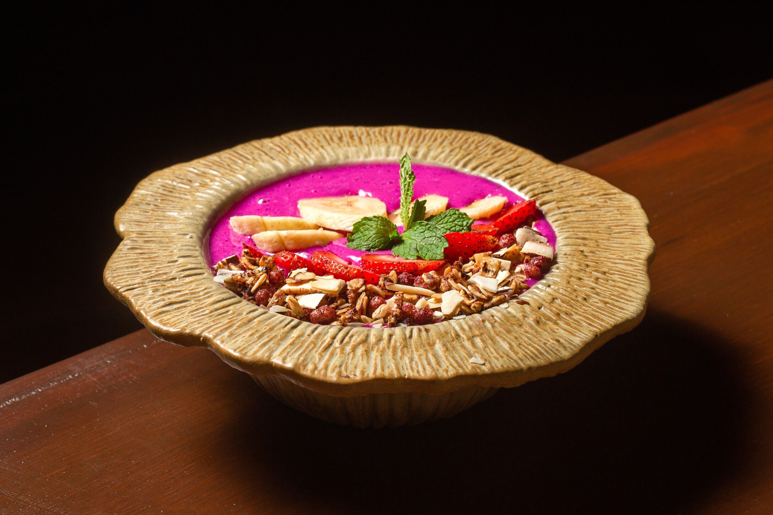 A dessert in a textured bowl on a wooden surface.