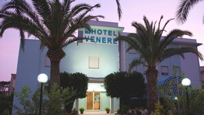 Un hôtel avec une enseigne indiquant « HÔTEL VENERE » et un escalier menant à l’entrée.