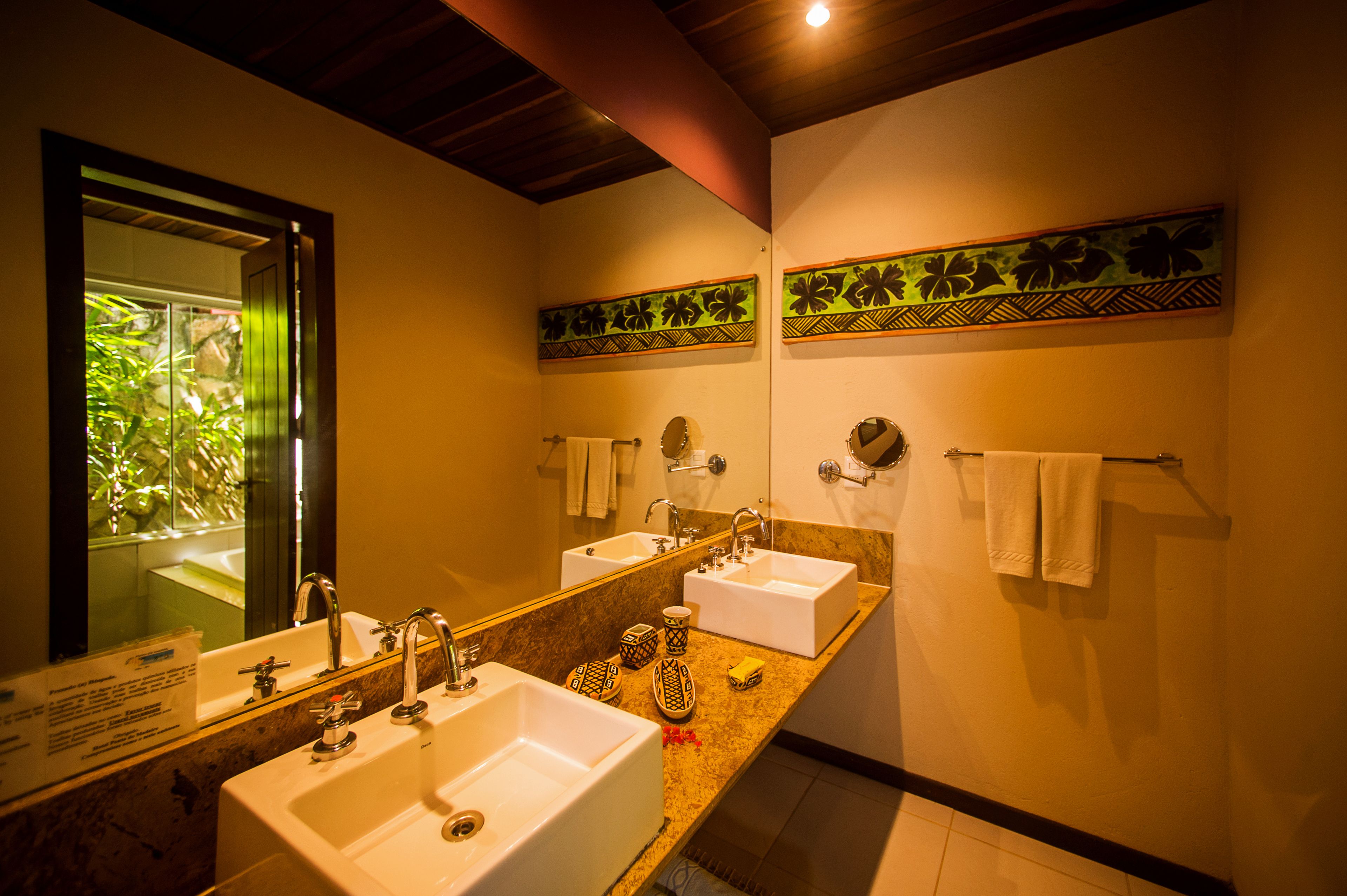 A bathroom with two sinks, a large mirror, and decorative wall panels.