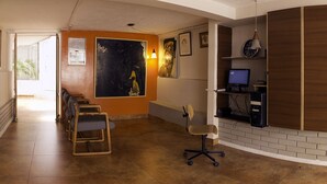 A reception area with a desk, computer, and seating. - Apartamentos Los Alcázares (Bogotá)
