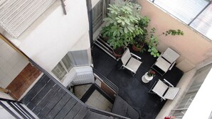 A multi-level indoor space with a staircase, seating area, and potted plants. - Apartamentos Los Alcázares (Bogotá)