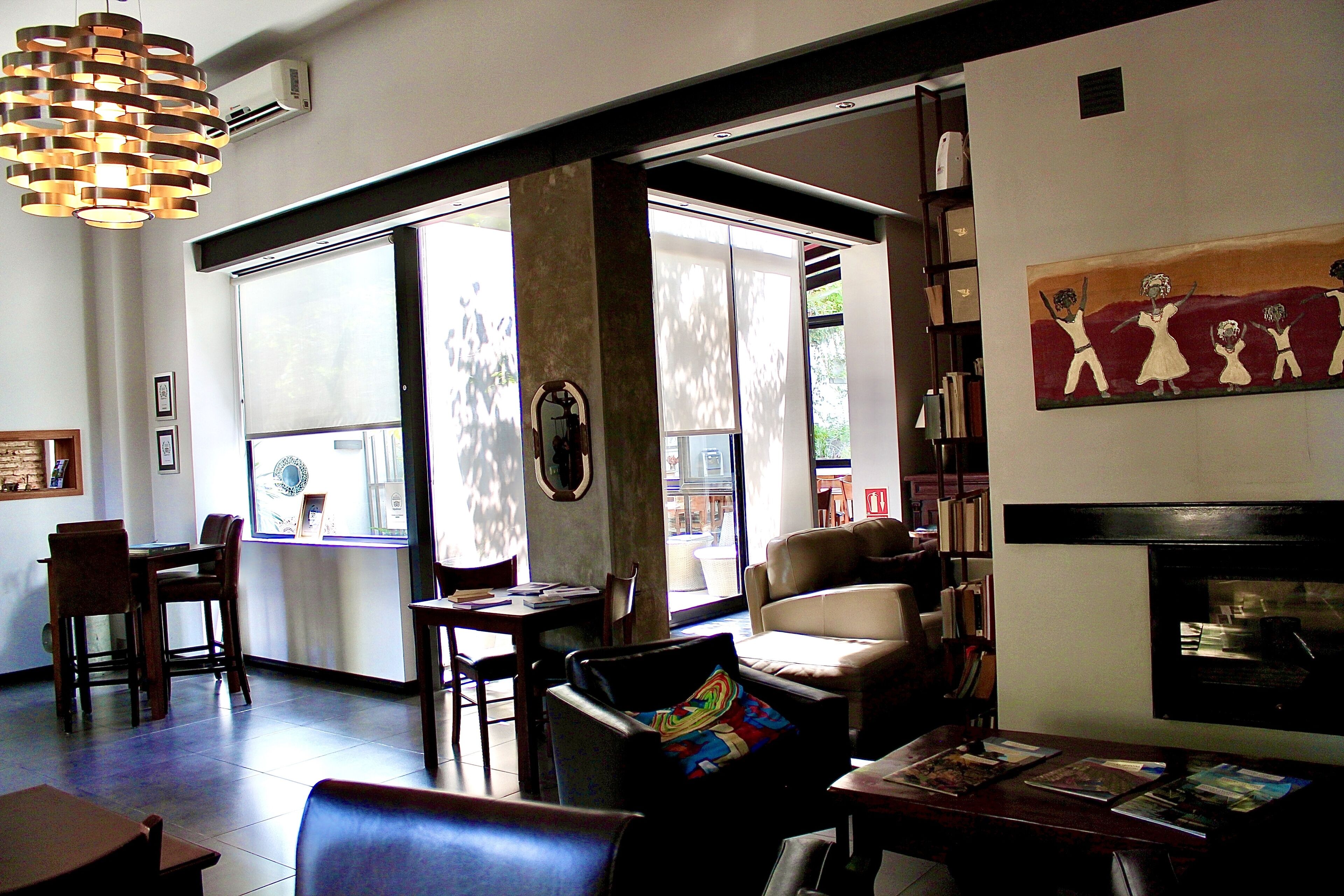A spacious room with a large window, a fireplace, and a collection of books on shelves.