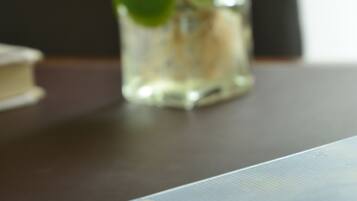 A close-up of a plant in a glass vase on a wooden table.
