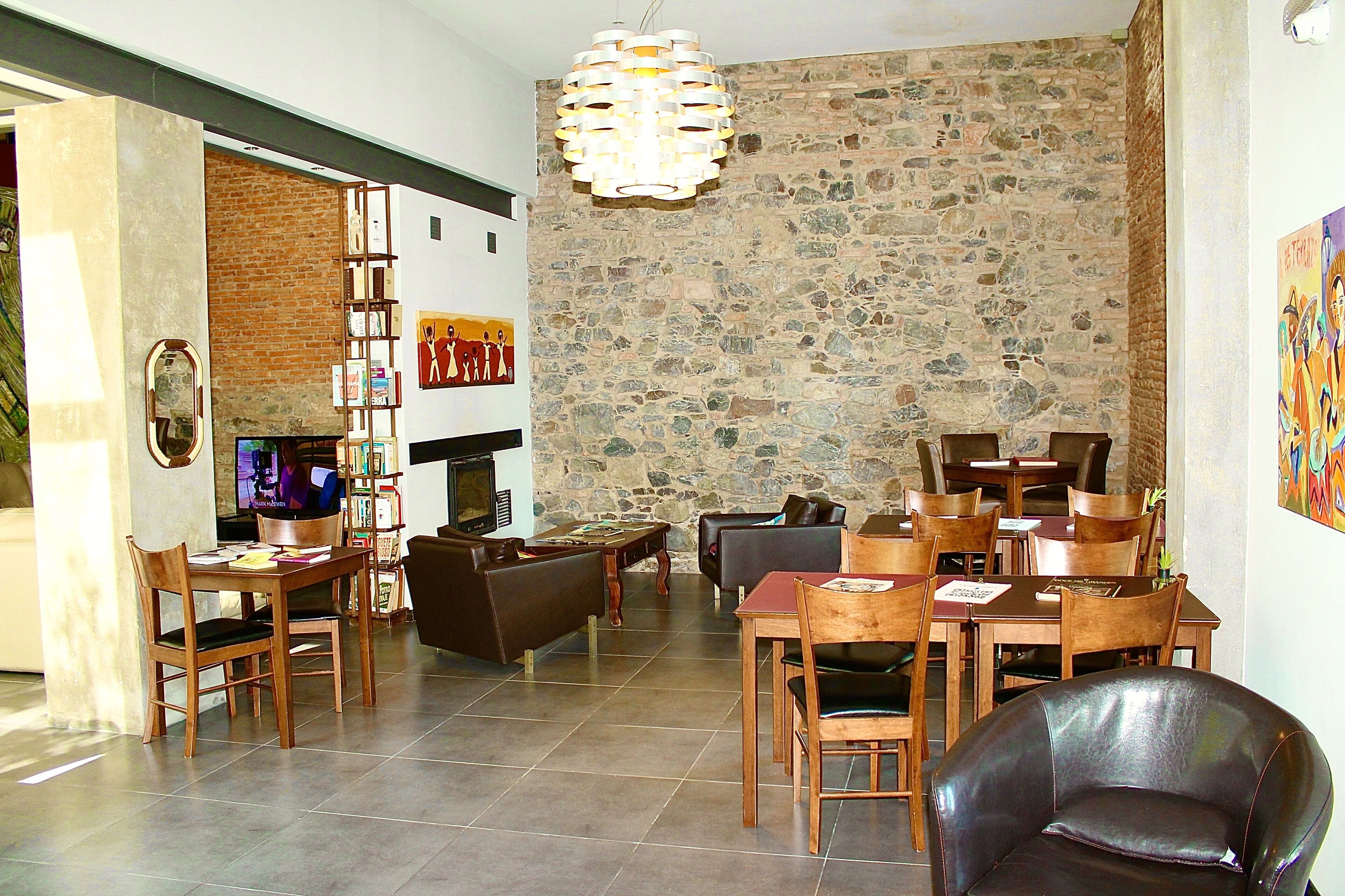 A spacious living area with a stone wall, wooden furniture, and a television.