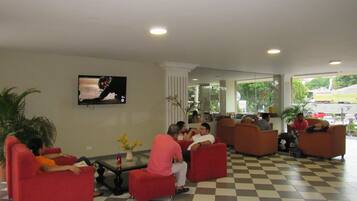 A lobby with red seating, a television, and a checkered floor.