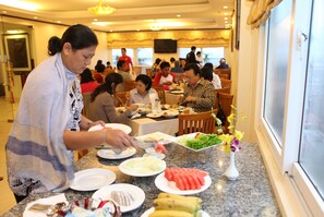 A restaurant with a marble counter, various dishes, and a television screen. - Sunny 3 Hotel Hanoi (Hanoi)