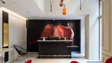 A modern reception area with a black reception desk, a large red sculpture, and a black chair.