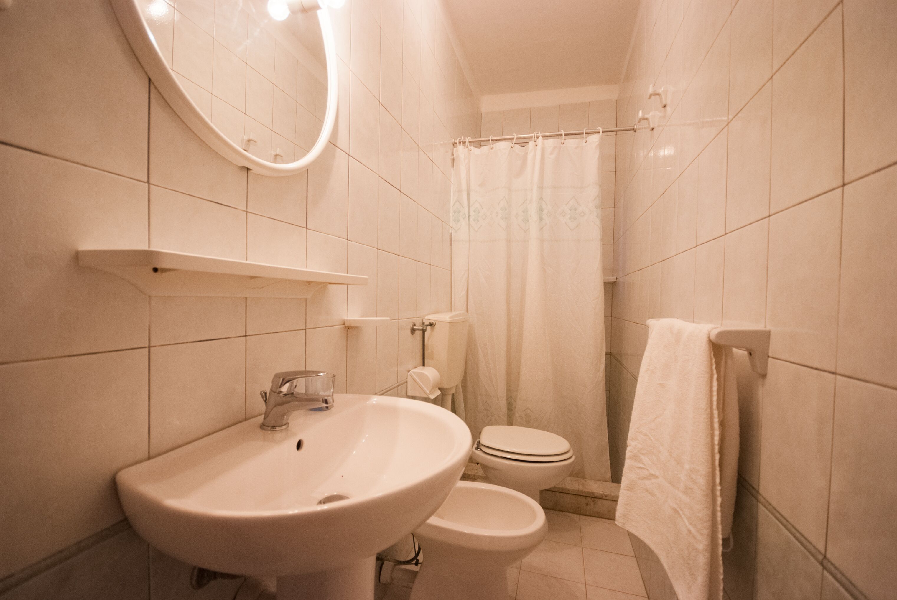 A bathroom with a sink, toilet, and shower curtain.