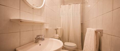 A bathroom with a sink, toilet, and shower curtain.