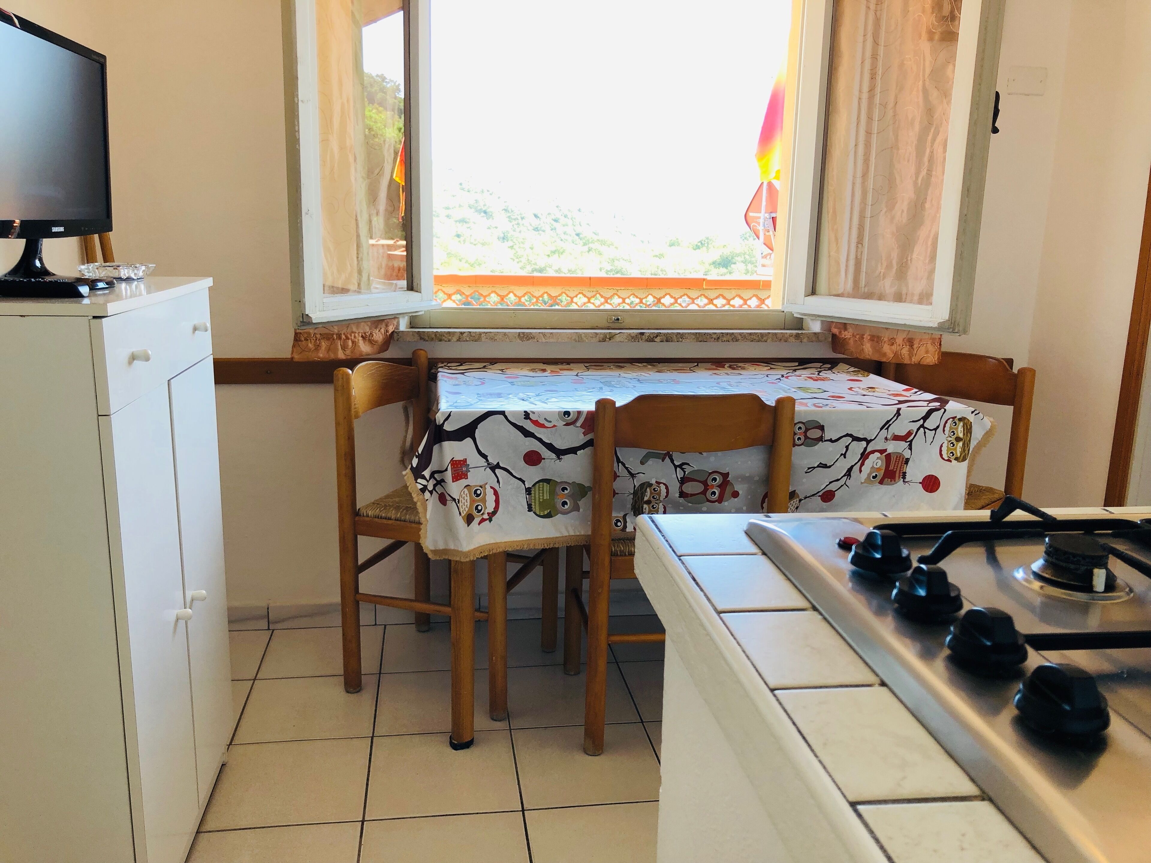 A kitchen with a dining table, chairs, a refrigerator, and a stove.