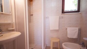 Une salle de bain équipée d’une douche, d’un lavabo et d’un bidet.