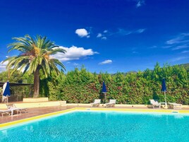 Una piscina al aire libre de temporada, sombrillas