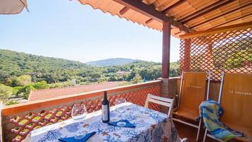 Una terraza con una mesa lista para dos, con vistas a un paisaje pintoresco.